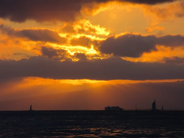 Pôr do sol como barcos navegam na água ao largo de Oahu — Fotografia de Stock