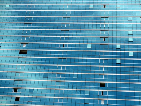 Finestre di vetro blu riflettono nuvole e cielo — Foto Stock