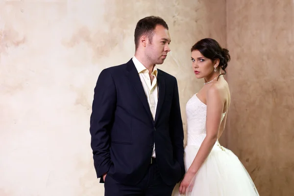 Bride and groom standing in empty room — Stock Photo, Image