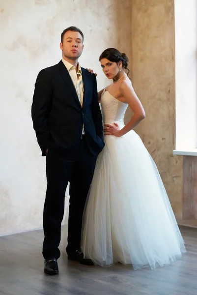 Bride and groom standing in empty room — Stock Photo, Image
