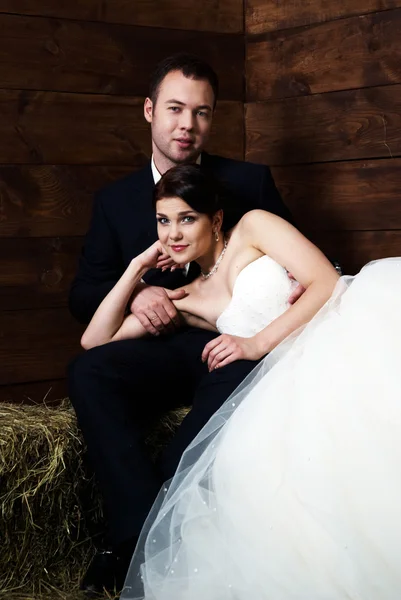 Mariée allongée sur les genoux du marié dans la grange — Photo