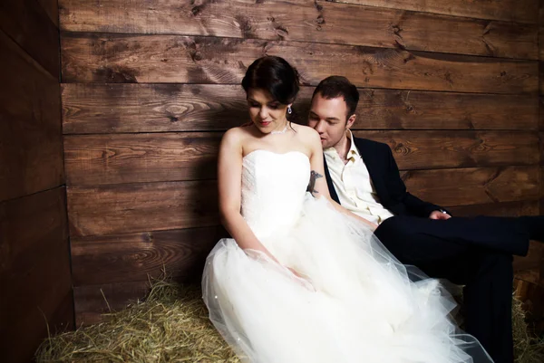 Coppia nei loro abiti da sposa in fienile con fieno — Foto Stock