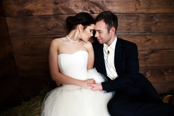 Couple in their wedding clothes in barn with hay — Stock Photo, Image