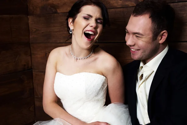 Casal em suas roupas de casamento no celeiro rindo — Fotografia de Stock
