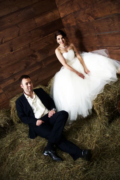 Paar in hun bruiloft kleren in de schuur met hooi — Stockfoto