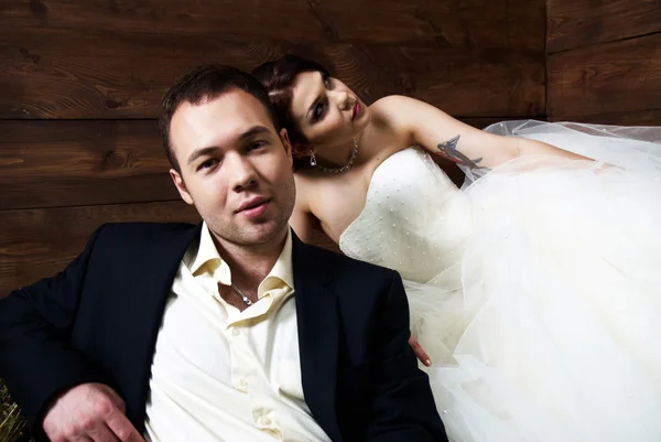 Casal em suas roupas de casamento no celeiro com feno — Fotografia de Stock