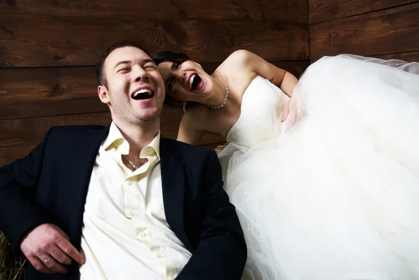 Couple in their wedding clothes in barn laughing — Stock Photo, Image