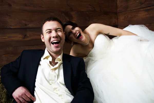 Пара в свадебной одежде в сарае смеется — стоковое фото