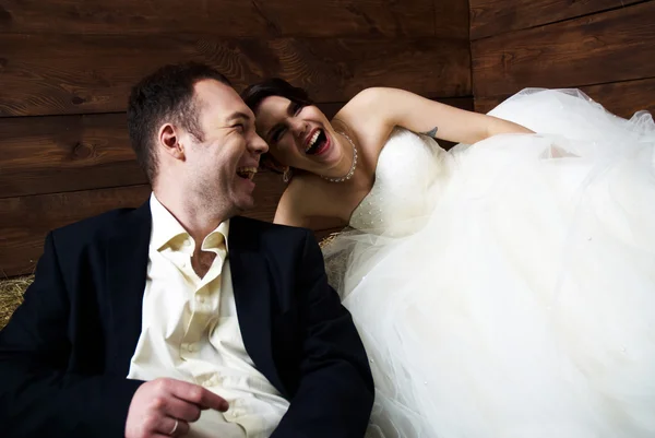 Para w ich stroje ślubne w stodole śmiejąc się — Zdjęcie stockowe