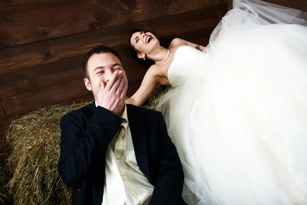 Couple dans leurs vêtements de mariage dans la grange rire — Photo