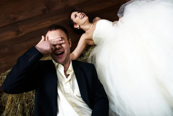 Paar in hun bruiloft kleren in de schuur lachen — Stockfoto