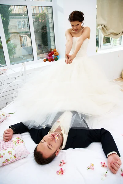 Νύφη και ο γαμπρός κοροϊδεύουμε στο υπνοδωμάτιο με ορχιδέες — Φωτογραφία Αρχείου