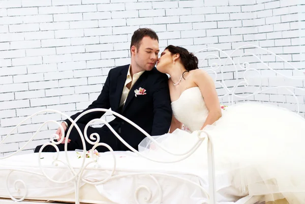 Mariée et marié assis sur le lit dans la chambre — Photo
