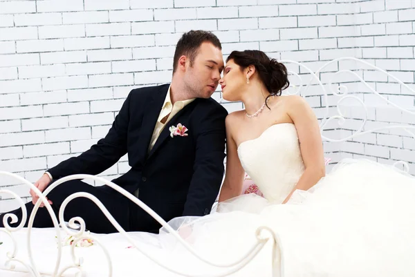 Noiva e noivo sentado na cama no quarto — Fotografia de Stock
