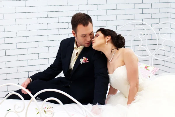 Menyasszony és a vőlegény ül ágyas hálószoba — Stock Fotó