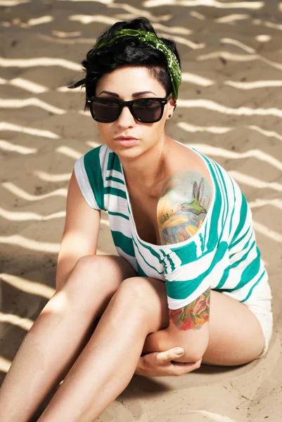 Очаровательная девушка с татуировкой в солнечных очках — стоковое фото