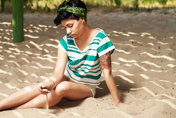 浜辺の入れ墨を持つ少女に砂を注ぐ — ストック写真
