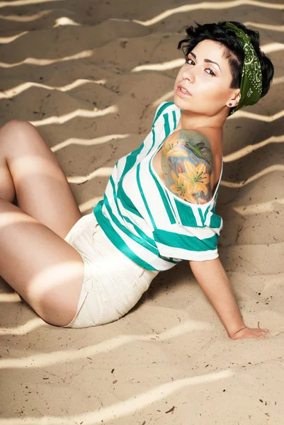 Roztomilá dívka s tetováním na pláži — Stock fotografie
