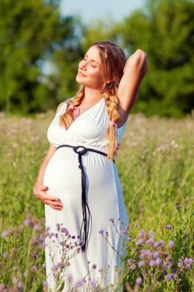 Красивая беременная женщина отдыхает в парке Стоковая Картинка
