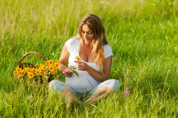 Beautiful pregnant woman relaxing in the park — Stock Photo, Image