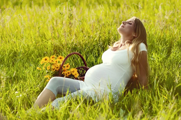 Mulher grávida bonita relaxante no parque Imagens De Bancos De Imagens