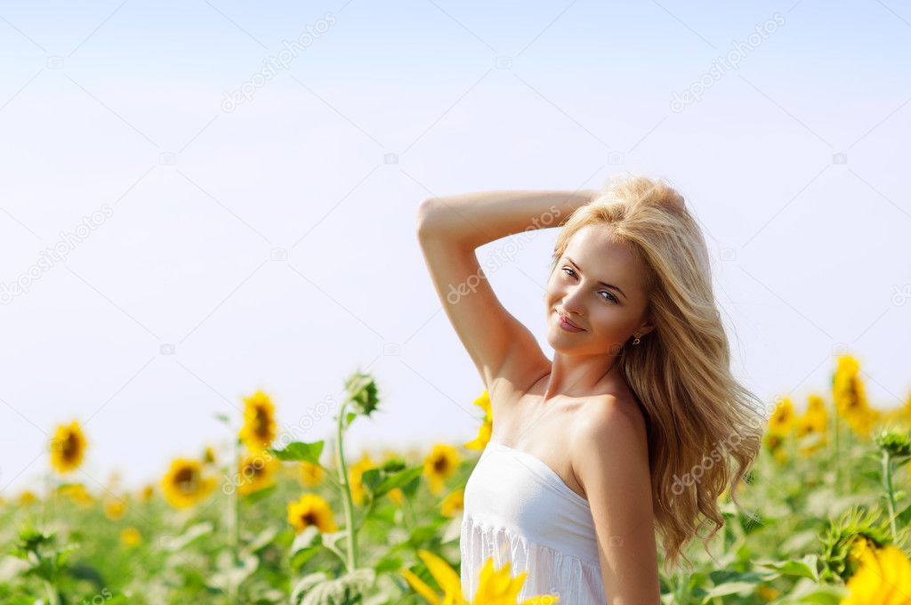 Young beautiful woman on field in summer