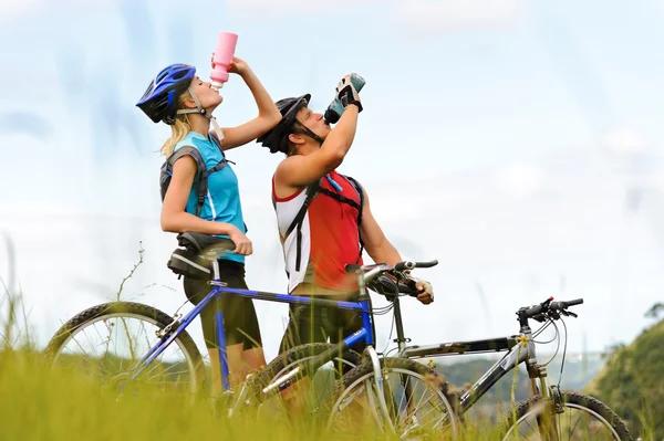 Mountain bike pareja bebiendo — Foto de Stock