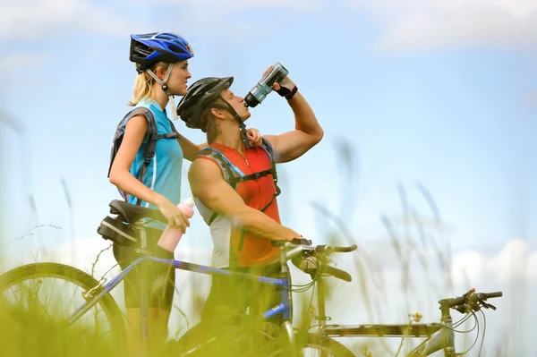 Mountain bike pareja bebiendo — Foto de Stock