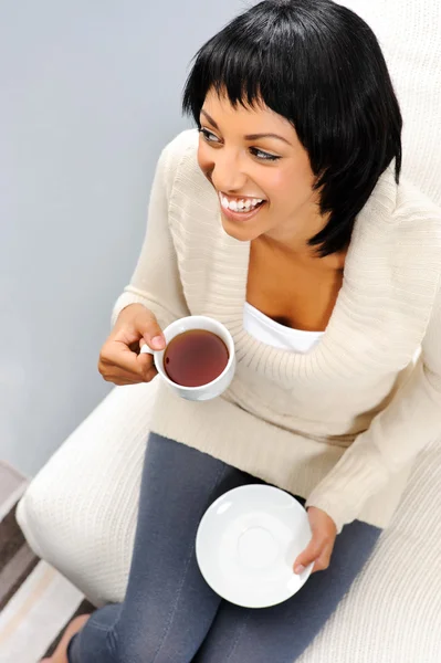 Гарненька жінка посміхається з чаєм — стокове фото