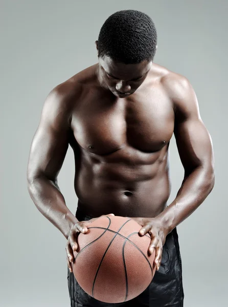 Мускулистый мужчина держит баскетбольный мяч — стоковое фото