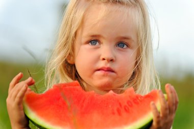 Healthy child eating watermelon clipart