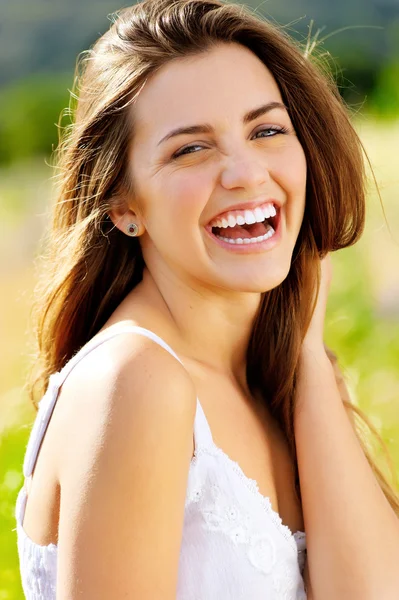 Leuk meisje lacht met vreugde buiten in de zon — Stockfoto
