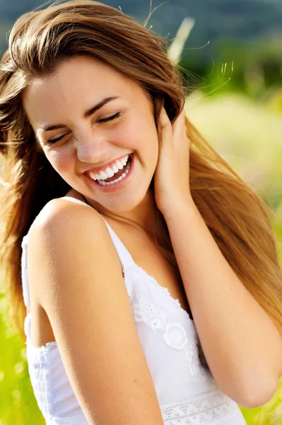 Söt tjej skrattar med glädje utomhus i solljus — Stockfoto