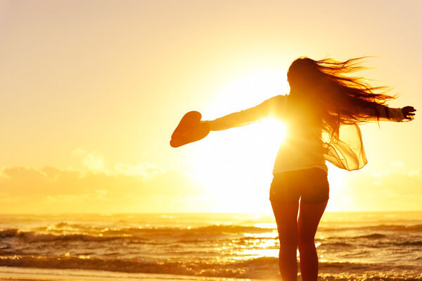 Carefree woman dancing in the sunset