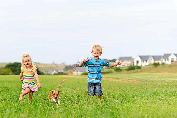 Roztomilá blonďatá děti běží v poli — Stock fotografie