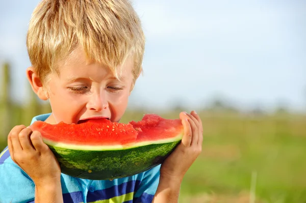 Hungry boy with watermelon outdoors — Stock Photo, Image