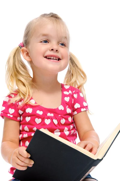Маленька дівчинка читає книгу і посміхається — стокове фото