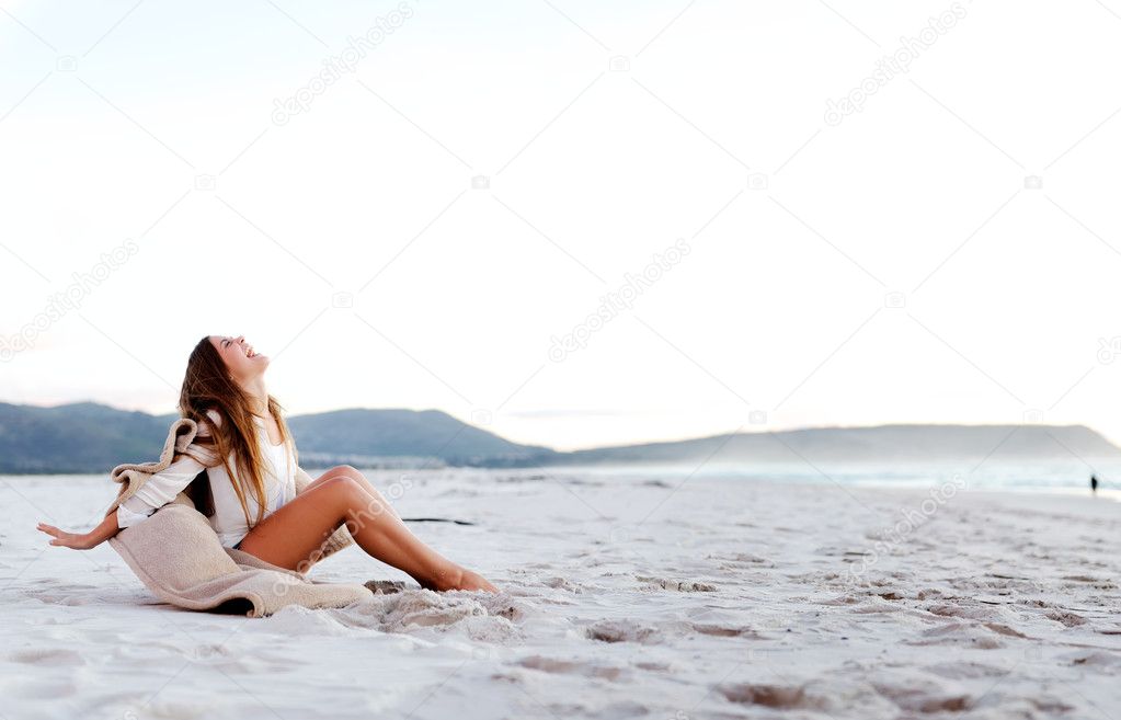 Beach girl sits on the sand