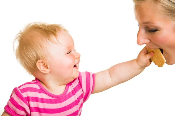 Infant baby learning to eat a biscuit — Stock Photo, Image