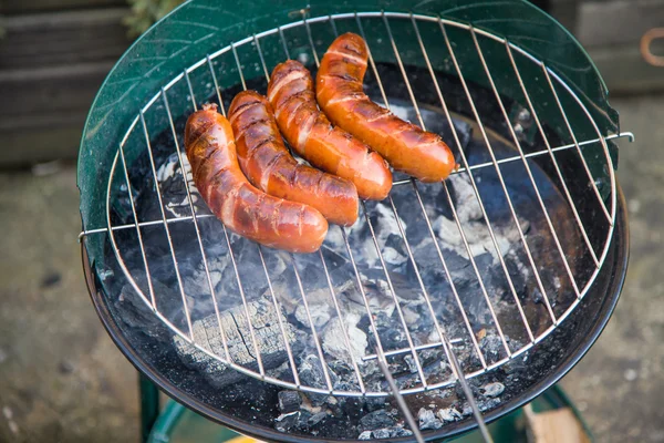 Smakelijke worst branden op hete barbecue — Stockfoto