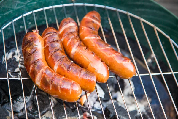 Tasty sausages burning on hot barbeque — Stock Photo, Image