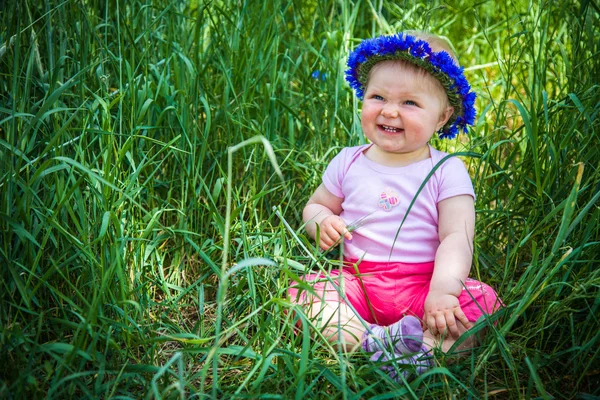 Mignon bébé fille assise dans l'herbe — Photo