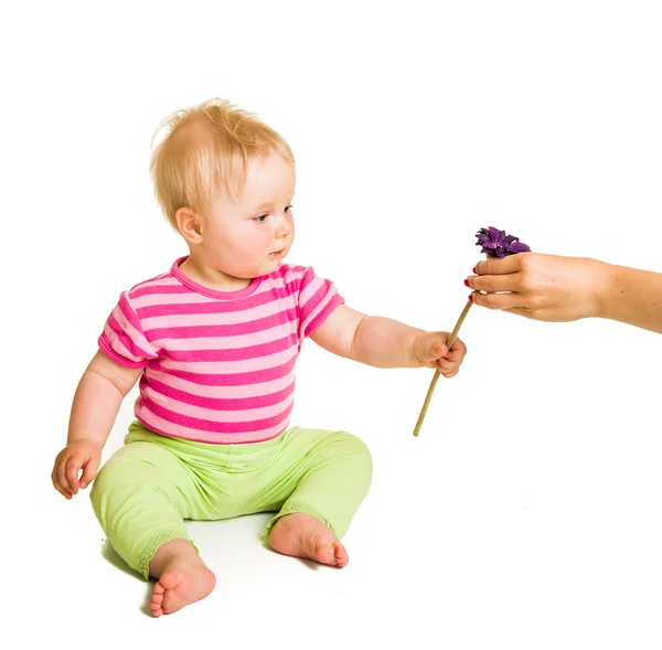 Spädbarn flicka ger blomma — Stockfoto