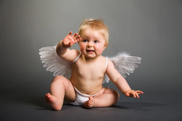 Säugling mit Engelsflügeln auf neutralem Hintergrund Stockbild