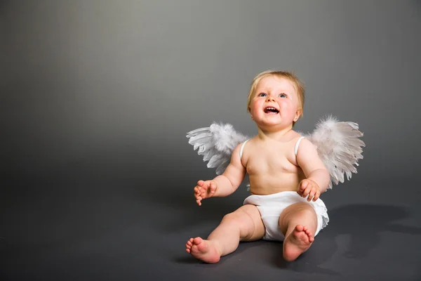 Säugling mit Engelsflügeln auf neutralem Hintergrund Stockbild