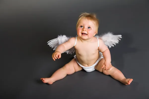 Bebê infantil com asas de anjo em fundo neutro Fotografia De Stock