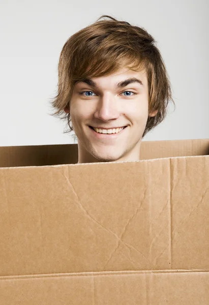 Homem dentro de uma caixa de cartão — Fotografia de Stock