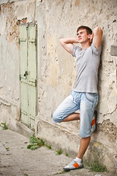 Genç adam bir grunge duvara yaslanmış — Stok fotoğraf