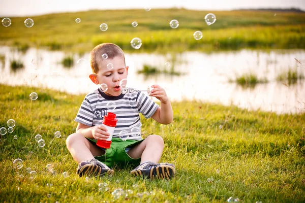 Pojken blåser såpbubblor — Stockfoto