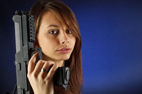 Ung flicka anläggning pistol — Stockfoto
